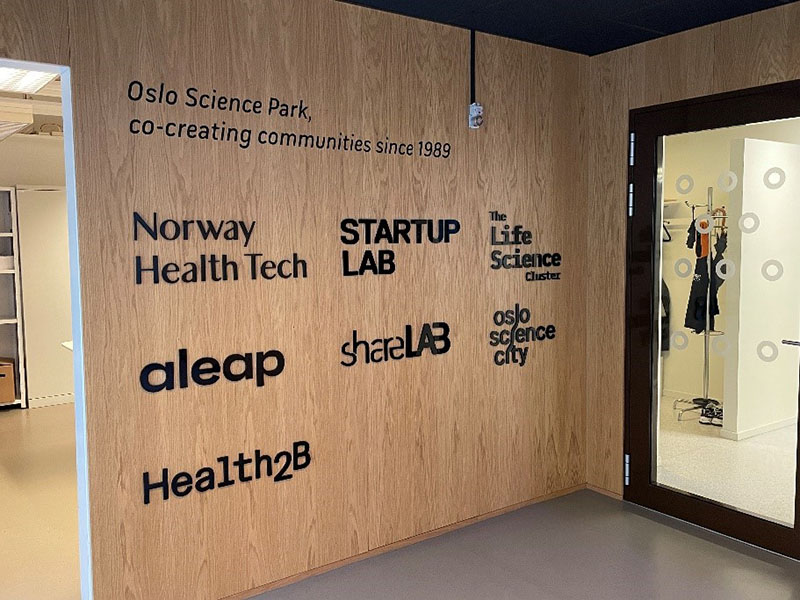 A picture of a wall that says "Oslo Science Park, co-creating communities since 1989" then lists departments of the Science Park.